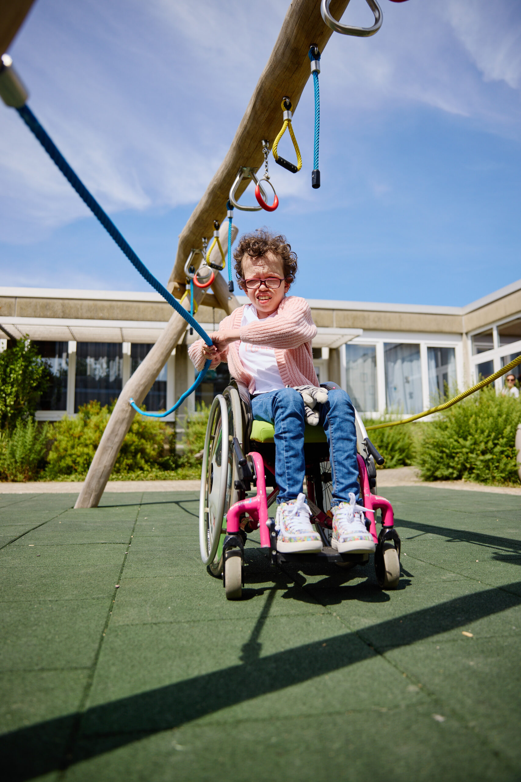Eine Jugendliche im Rollstuhl hangelt an einem inklusiven Spielgerät im Schulhof der Oberlin-Schule in Kork.